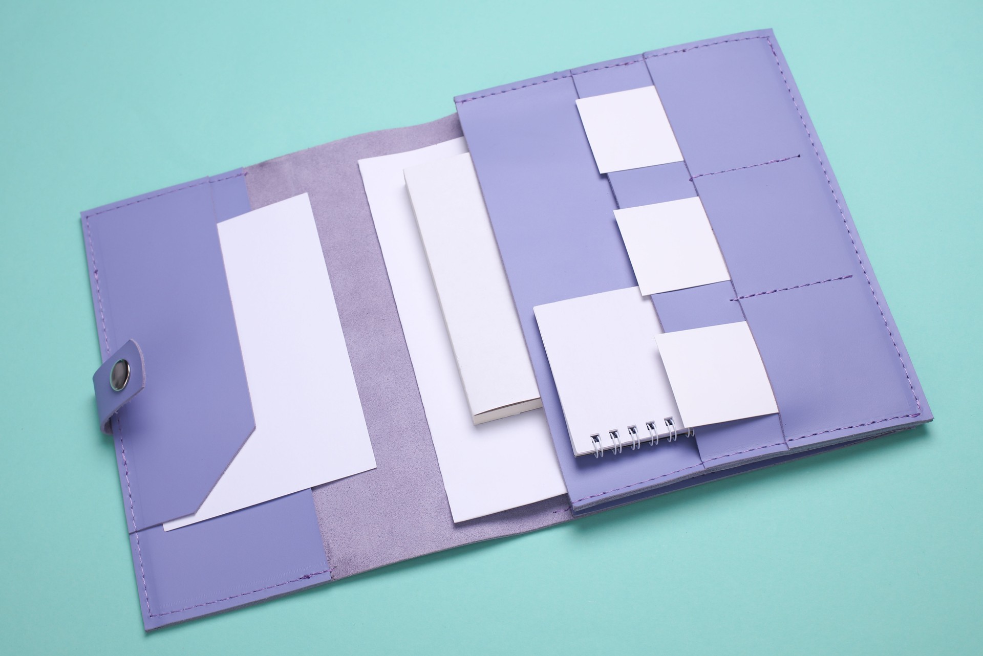 Purple Leather organizer folder for paper with white business cards, notebook on blue background